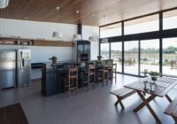 Espaço gourmet com ilha de granito, churrasqueira, refrigeradores e vista para o lazer do Condomínio Alphaville Pelotas.