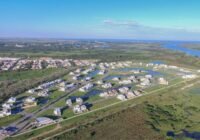 Vista aérea panorâmica do Condomínio Lagos de São Gonçalo, exibindo casas modernas ao redor de lagos azuis, estradas pavim...