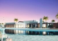 Clube social contemporâneo do Condomínio Veredas iluminado ao anoitecer, com ampla piscina e deck de madeira, cercado por ...
