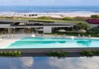 Área de lazer do Mirador Playa Arenas - Capão Novo: piscina moderna, edifício com telhado verde, espreguiçadeiras e vista ...