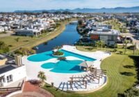 Vista aérea do complexo de piscinas e áreas de lazer do Condomínio Sea Coast Beach Village Xangri-Lá, com lago e casas mod...