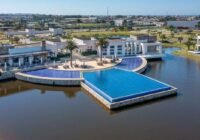 Vista aérea do complexo de lazer do Condomínio Enseada Lagos de Xangri-Lá, com piscinas de mosaico azul e clube moderno à ...
