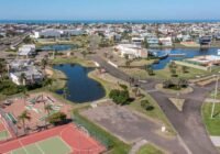 Vista aérea do Condomínio Enseada Lagos de Xangri-Lá, mostrando lagos, casas modernas, quadras esportivas e mini-golf sob ...