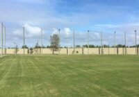 Campo de futebol gramado com trave branca, rede de proteção e postes de madeira, no Condomínio Riviera, em Xangri-Lá RS.