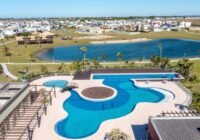 Piscinas de design, decks de madeira, lago natural e área residencial do Condomínio Riviera - Xangri-Lá RS, com gramados e...